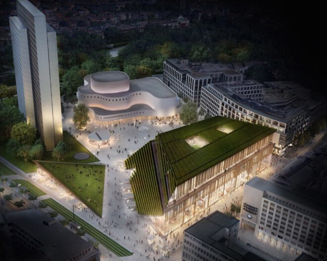 aerial view of trapezoid-shaped building with sloping green roof at night