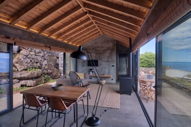 living area with gray sofa, wood dining set and wood-burning stove