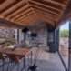 living area with gray sofa, wood dining set and wood-burning stove