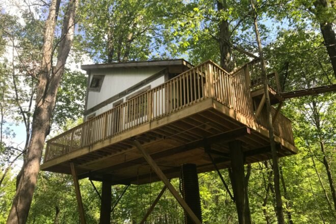 a small treehouse in Ohio is surrounded by greenery and trees