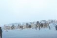 rendering of people skiing near buildings with gabled roofs