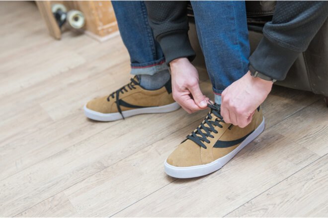 person ties light brown shoes