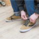 person ties light brown shoes