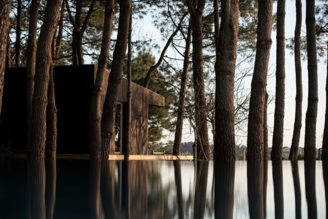 black cabin overlooking water