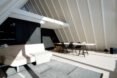 beige couch and long dining table under sloped ceilings