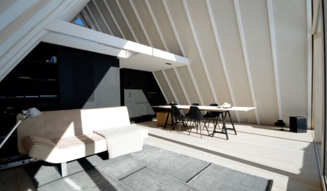 beige couch and long dining table under sloped ceilings