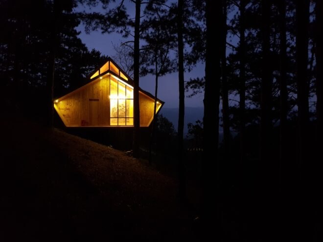 wood cabin lit up at night