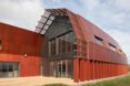 elongated building with reflective red facade
