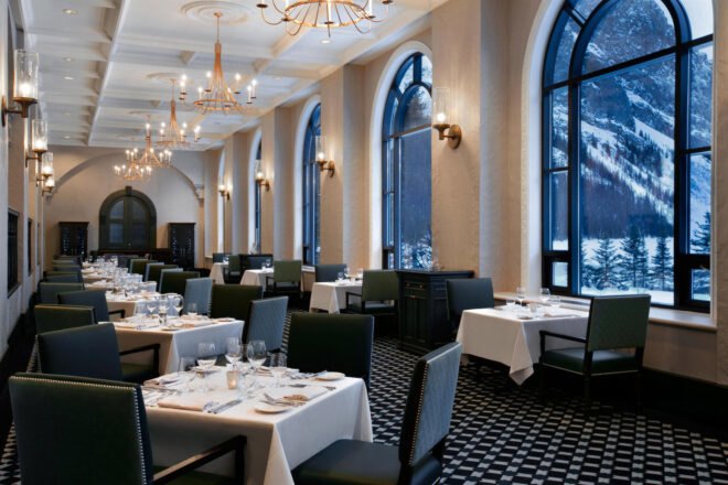 dining room of the hotel with large windows with snow covered mountain views