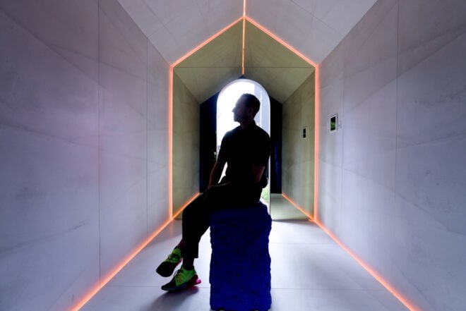 silhouette of man sitting in the middle of a white room