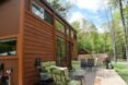 wooden tiny home with seating on large deck