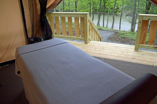 a single bed on a wooden deck