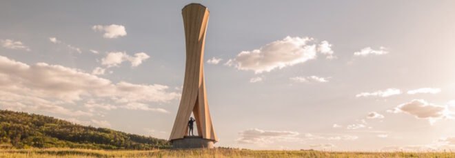 twisted wood tower on hilly landscape