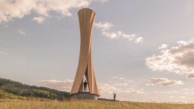 two people standing around twisted wood structure