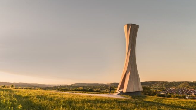twisted wood tower on hilly landscape at sunset
