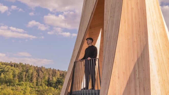 person standing on balcony of twisted wood structure