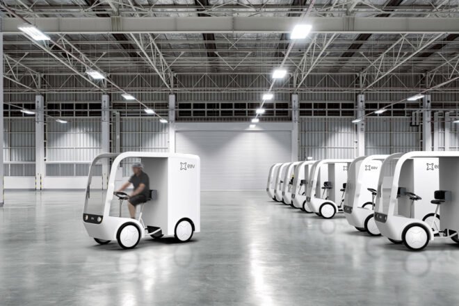 small white electric cargo quadricycle at a warehouse