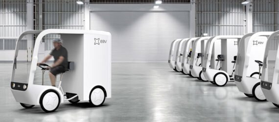 small white electric cargo quadricycle at a warehouse