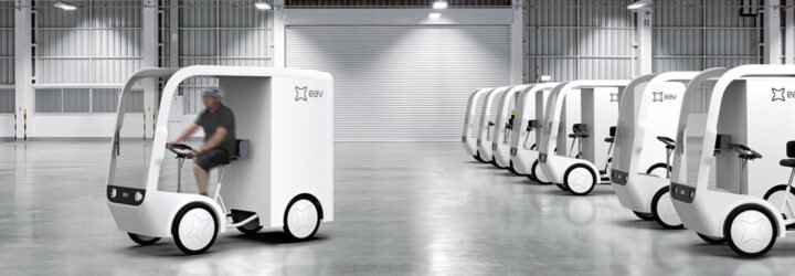 small white electric cargo quadricycle at a warehouse