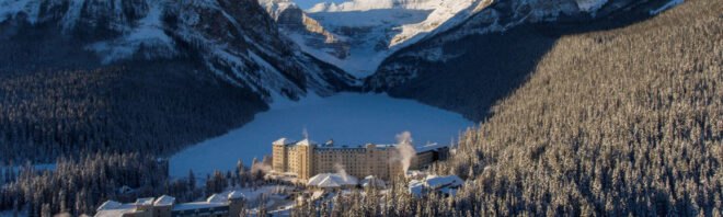 hotel is nestled in between mountains and forest covered in snow