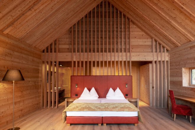 wood-lined bedroom with huge red bed