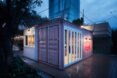 small gray shipping container lit up at night
