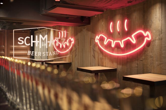pink hot dog-shaped neon signs on a wall