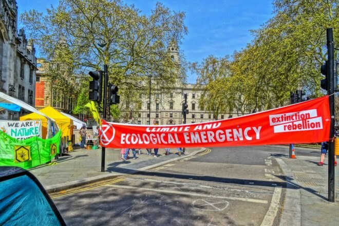 Red sign in London street that reads "Climate and Ecological Emergency"