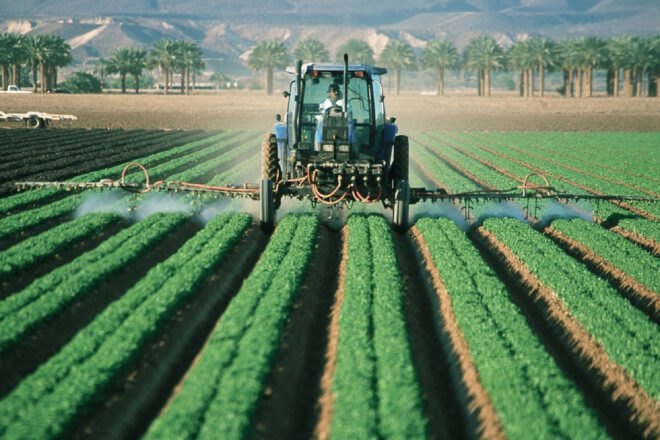 farmer sprays pesticide on agricultural fields