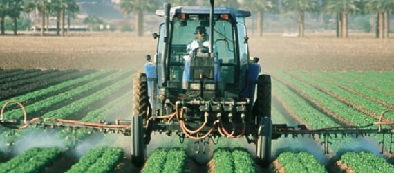 farmer sprays pesticide on agricultural fields