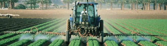 farmer sprays pesticide on agricultural fields