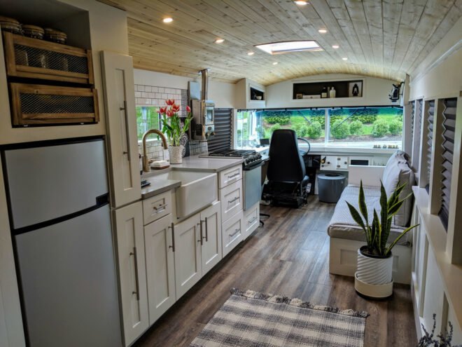 inside of a school bus with white walls, wood floors and contemporary furnishings