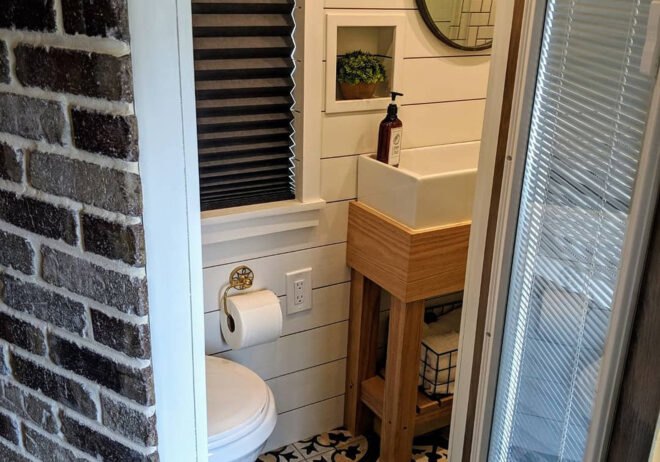 door open to bathroom with shiplap walls