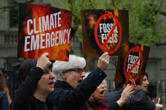 protestors holding "Climate Emergency" signs