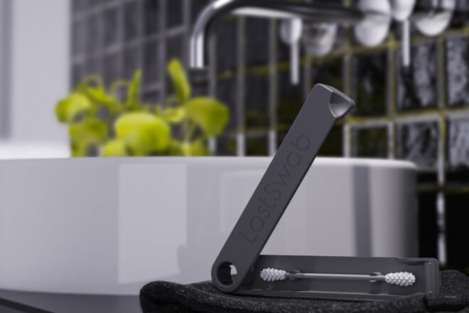 black reusable ear cleaner on a black towel in a dark bathroom