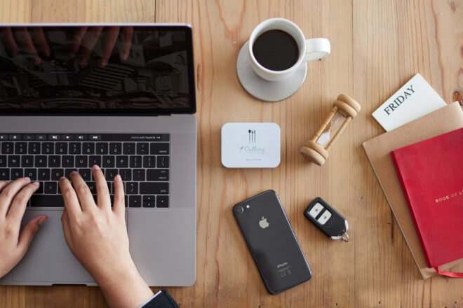 small white box of cutlery beside coffee mug and laptop