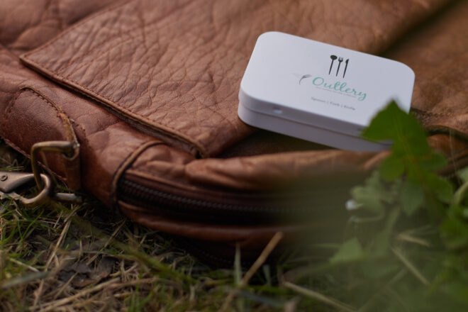 small white box of cutlery on brown backpack