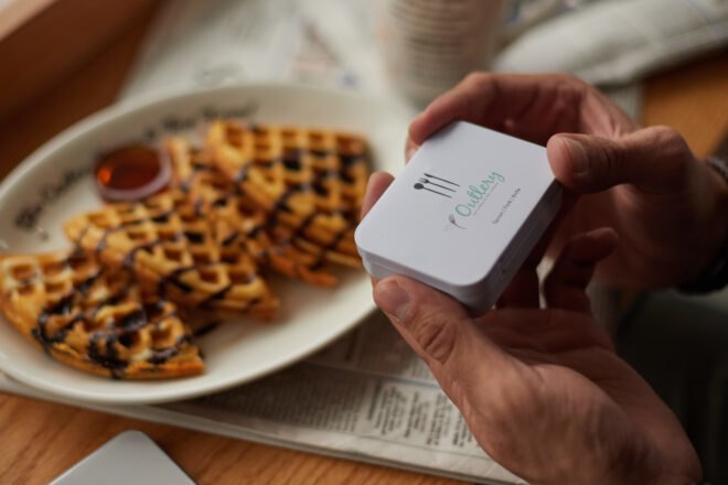 person opening small white box with cutlery inside