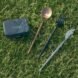 reusable cutlery beside small black box on grass