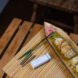 one chopstick and one disassembled chopstick beside plate of sushi