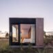 glass facade revealing a minimalist bedroom inside