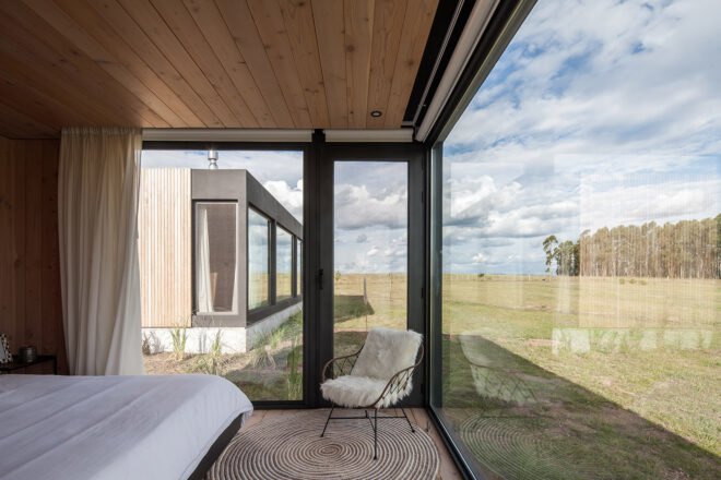 white bed in room with glass walls