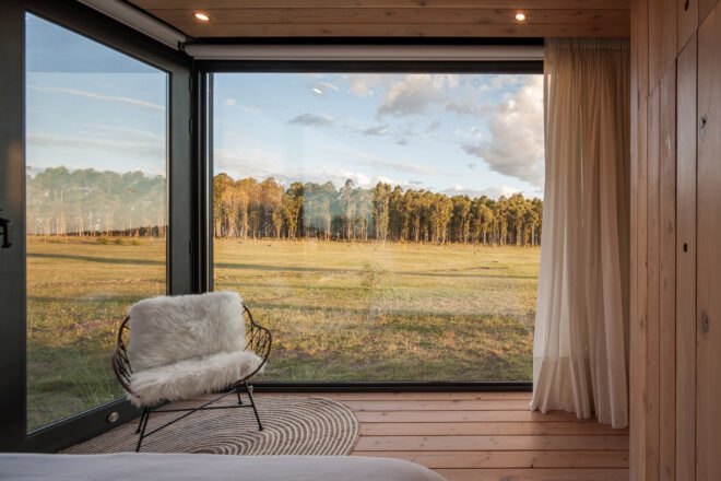 furry white chair near two glass walls