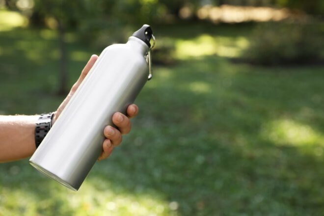 hand holding a steel water bottle