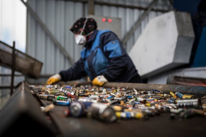 woman recycling batteries