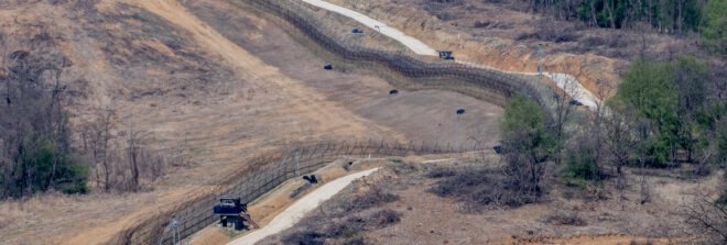 Korean DMZ zone with barbed wire and fences protecting empty land