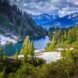 Glacier National Park in Montana filled with a lush forest and river with snow covered mountains in the background