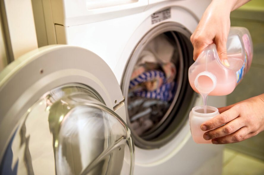 person pouring pink detergent 