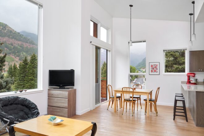 white room with tall ceilings and small wood table