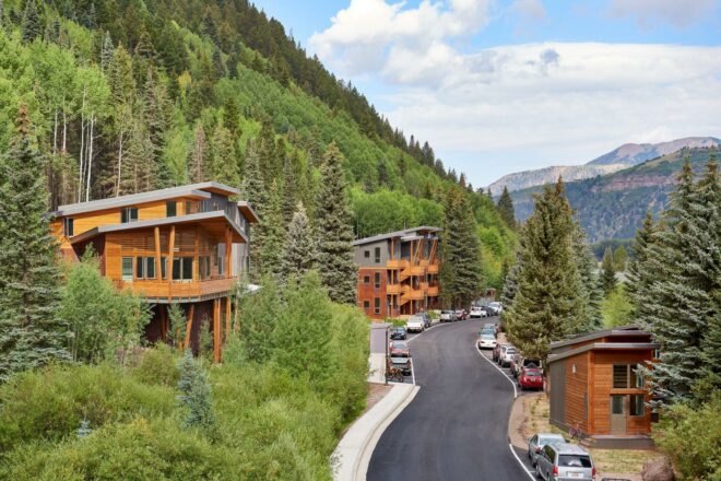 road between tiny homes and apartment buildings with mountains in background
